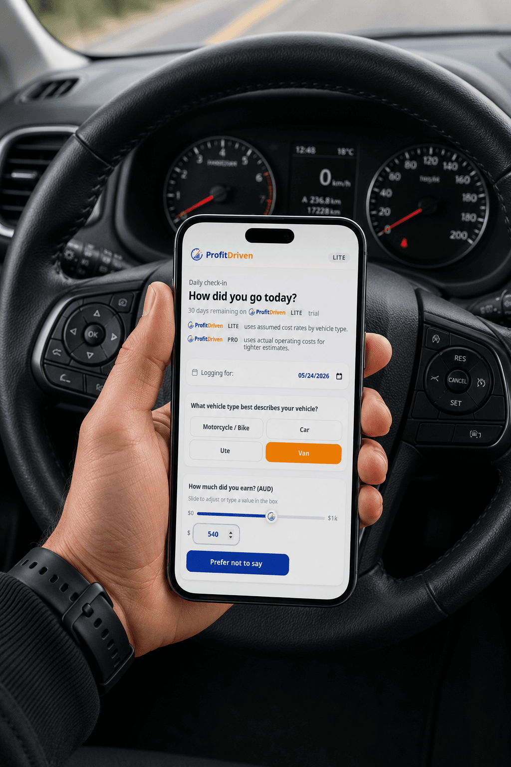 Hand holding a smartphone displaying the ProfitDriven app daily check-in screen inside a car.